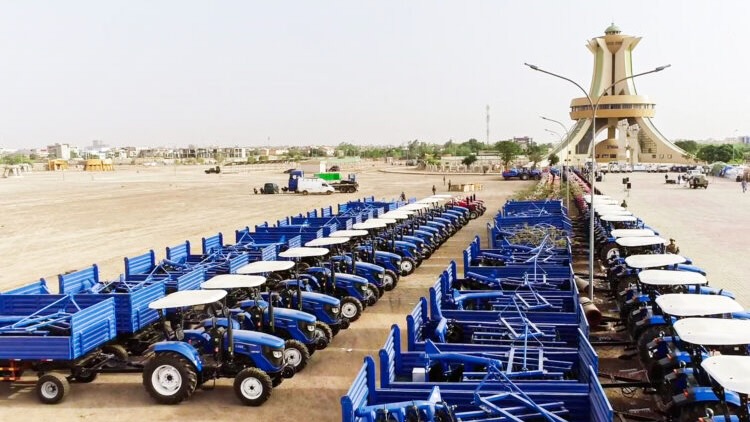 Lines of blue tractors, part of the agricultural machinery being distributed to farmers by the government
