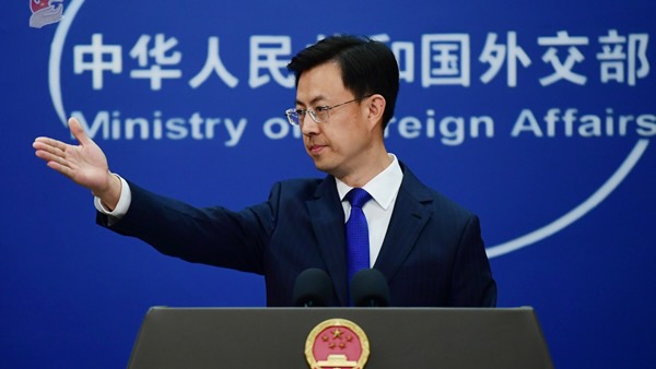 Guo Jiakun, spokesperson of the Chinese Ministry of Foreign Affairs, standing in front of blue MFA background