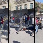 Protesters tearing down steel fence Zocalo Mexico City