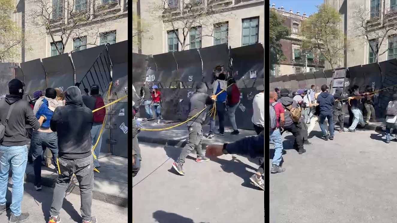 Protesters tearing down steel fence Zocalo Mexico City