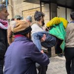 An injured man is carried off by several people in Syria's Aleppo