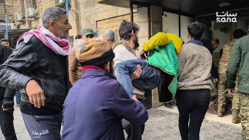 An injured man is carried off by several people in Syria's Aleppo