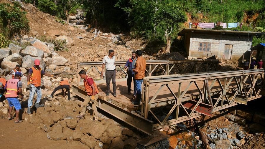 People repair a collapsed bridge affected by Cyclone Ditwah in Badulla District, Sri Lanka, Dec. 13, 2025.