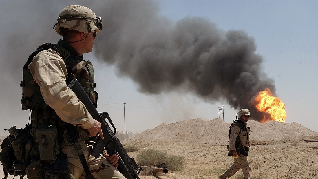 US Navy in Iraq near a fire in oil field.