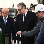 Serbian President Aleksandar Vučić looks at military products on table