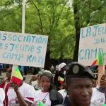 Malian people hold pro-government signs