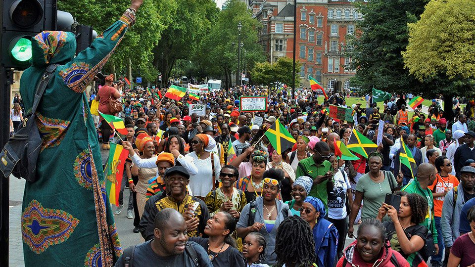 People of the African diaspora in London wave flags of their countries and march for reparations